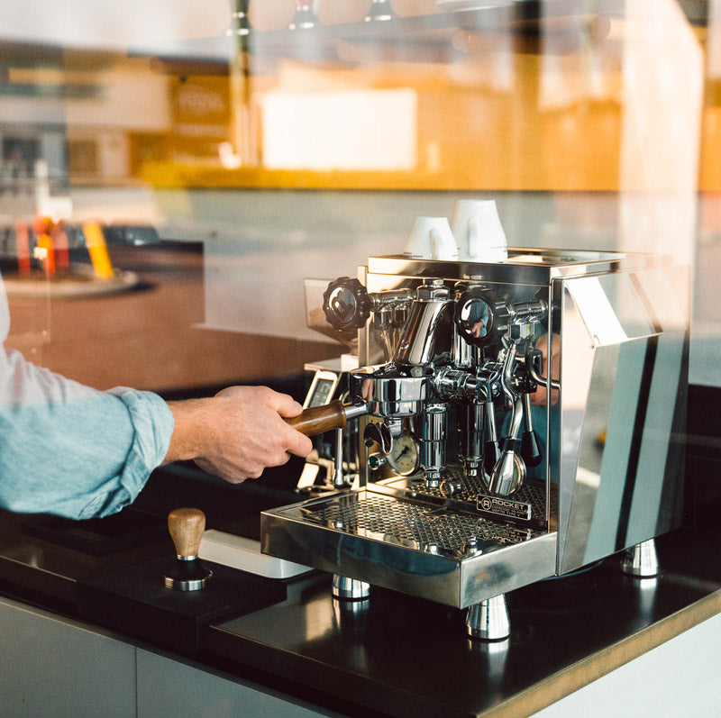 A technician servicing an espresso machine in the Osborne Park workshop